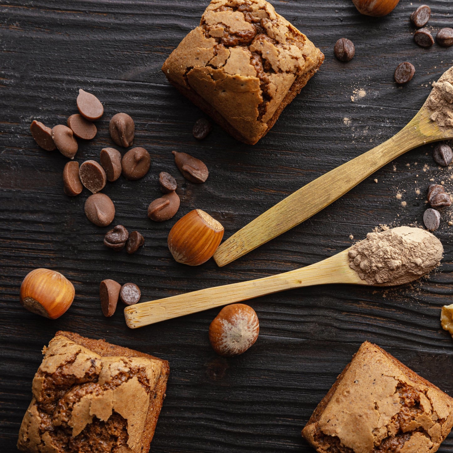 Top view of several brioche bites with nuts, wooden teaspoons and blackberries used as décor.